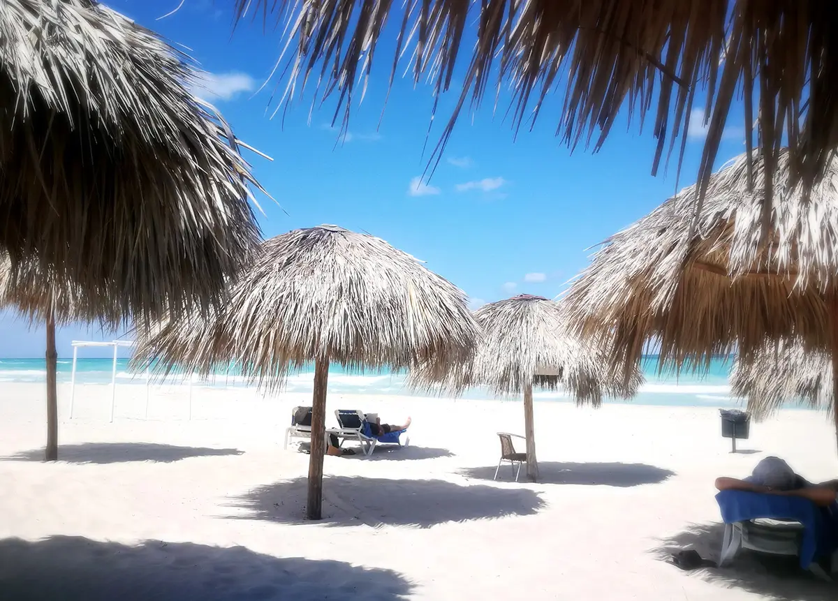 People relaxing on a white-sand beach in Cuba