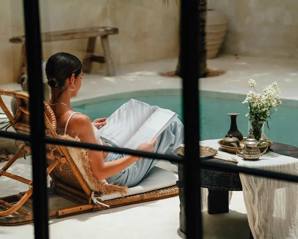 A person sits beside a private pool in hotel accomodation