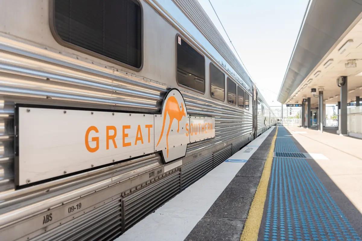 The Great Southern train at a station. It's log is shown on the side of the train