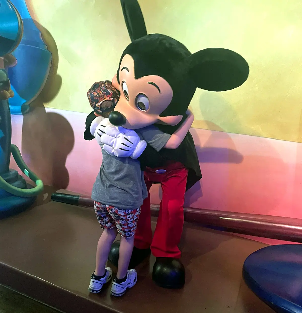 A child hugs a Mickey Mouse character at Disney World
