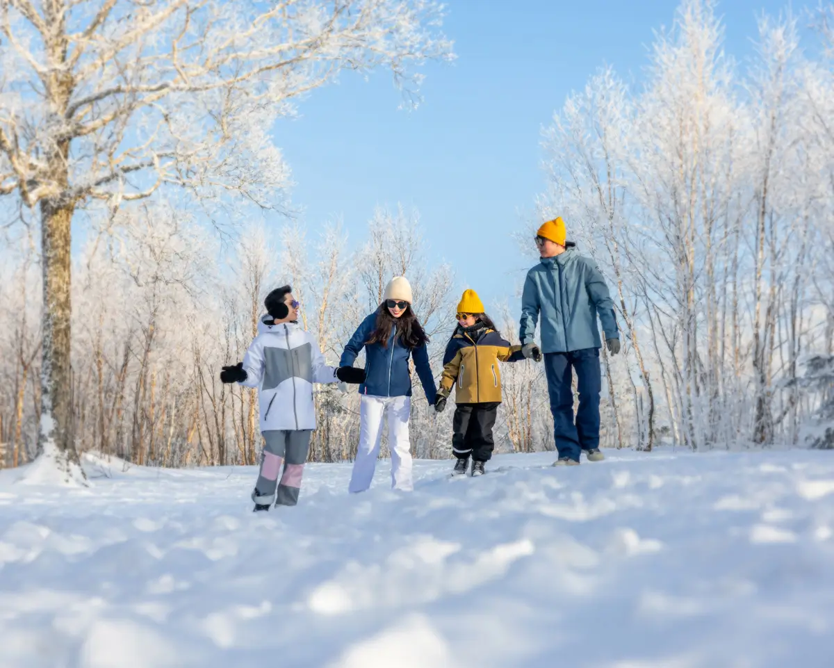 A family dressed in snow gear together in the snow in China