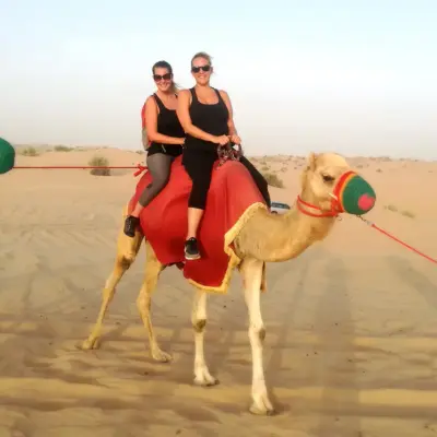 Two people riding a camel
